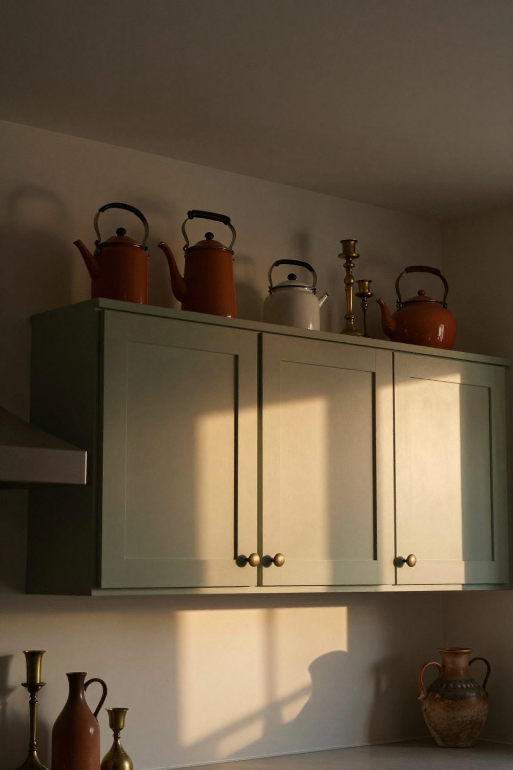 Collection of vintage enamel coffee pots and kettles on top of kitchen cabinets