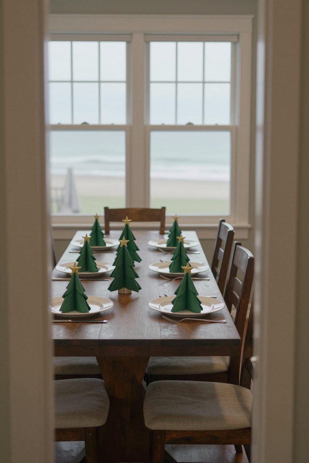 Napkins folded in a Christmas tree shape on plates with a small star