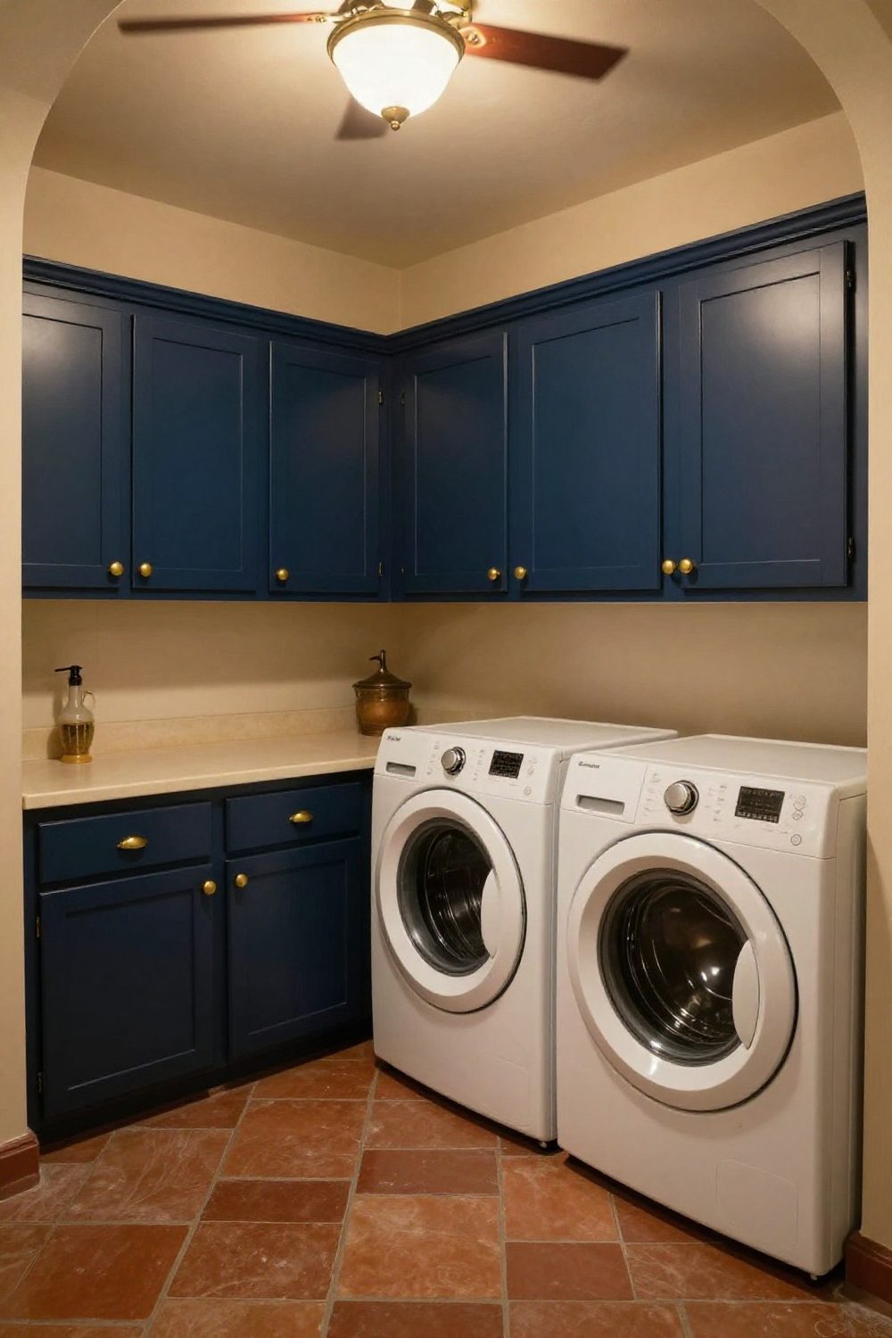 Laundry room with upper cabinets painted navy and brass hardware